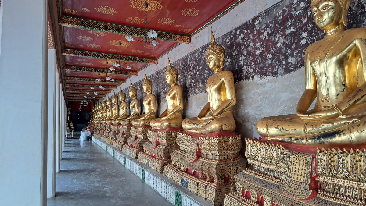 Wat Suthat 回廊に並ぶ仏像群｜ラビアンの坐像列と赤い天井装飾